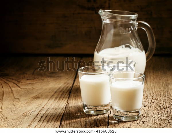 Goat milk in glasses, vintage wooden background,\
selective focus