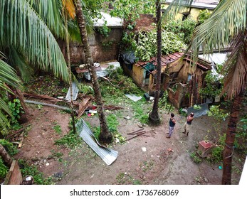 Gobardanga, West Bengal, India - May 21, 2020 : The Subsequent Damage Of The Amphan Cyclone. Two Men See They're Housebroken Down Due To Amphan Cyclone. Trees Branches Fall Over That House.