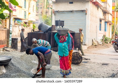 Gobardanga,West Bengal,India-December 15,2019:Asian Construction Worker Carrying Black Stone To The Asphalt Mixer.