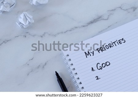 God first, top priority list, handwritten text on a spiral notebook with black marker. Seek first His Kingdom and righteousness, Matthew 6:33, Christian biblical concept, top view, a close up.