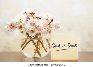 God Is Love - Christian Lettering, Biblical Phrase And Bouquet Of Pink Flowers In Vase