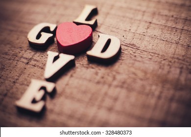 God is love concept text lying on the rustic wooden background.