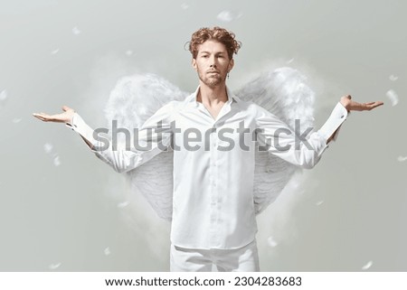 God of love Cupid. Courageous handsome male Cupid angel in white clothes and with white wings. White background. Valentine's Day.