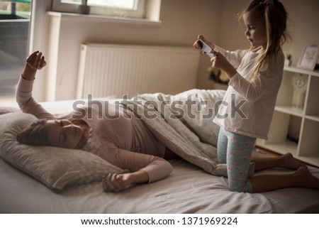 Similar – Happy boy jumping and playing over the bed with his family in a relaxed morning. Weekend family leisure time concept.