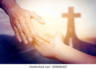 God salvation concept. Close up of God's hand reaching a human hand with Cross symbol on end of road - Shutterstock ID 2038582607
