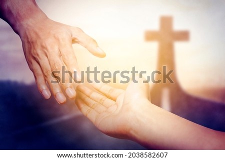 God salvation concept. Close up of God's hand reaching a human hand with Cross symbol on end of road