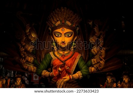 Goddess Durga idol at decorated Durga Puja pandal, colored light, at Kolkata, West Bengal, India. Durga Puja is biggest religious festival of Hinduism and is now celebrated worldwide.
