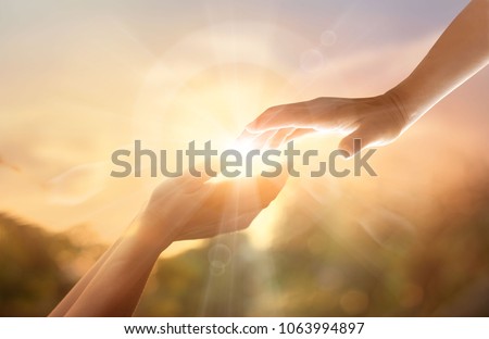 God's helping hand with the white cross on sunset background. Day of remembrance and good friday concept