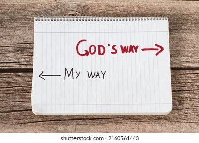 God's way, a handwritten text quote and arrows in a white notebook page placed on a wooden background. Follow the way of life with obedience to God Jesus Christ, biblical concept. Top view.	 - Shutterstock ID 2160561443