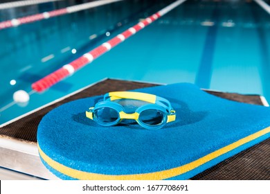 Goggles On Blue Flutter Board Near Swimming Pool