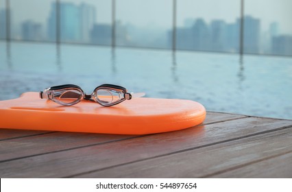 A goggles and orange color pool kickboard, accessories for swimming - Powered by Shutterstock