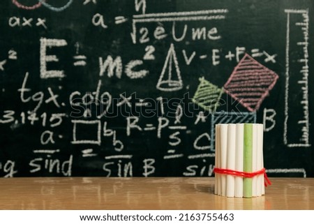 Going back to school concept with blackboard full of numbers and a busy student desk