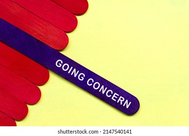 Going Concern Text On Purple Color Wooden Stick. Business And Accounting Concept.