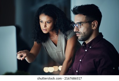 Going The Extra Mile For Success. Shot Of Two Colleagues Using A Computer Together During A Late Night At Work.