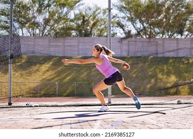 Going for her record. Shot of a young athlete practicing the discus. - Powered by Shutterstock