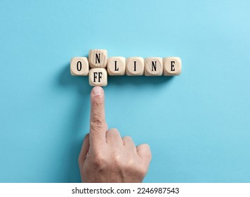 Going offline. To choose between online and offline. Digital detox. Male hand transforms the word online to offline on wooden cubes.