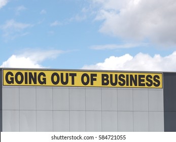 Going out of business writing in black on yellow letters on a white claded industrial building, Melbourne 2016