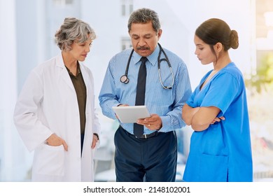 Going Over Some Medical Records. Shot Of Three Healthcare Professionals Looking Over Medical Records On A Tablet.