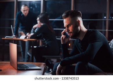 Going to receive some help. Team of young business people works on their project at night time in the office.