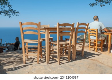 Gokceada Canakkale, Turkey July 27,2023 coastline and a cute village tea garden view with wooden chairs and table in Tepeköy village, Çınaraltı-Pinarbasi location, Aegean Turkey - Shutterstock ID 2341204587
