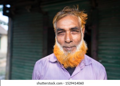 Golap Gram / Bangladesh – January 18, 2019: Portrait Adult Bangladeshi Man With Orange And White Beard Smiles To Camera