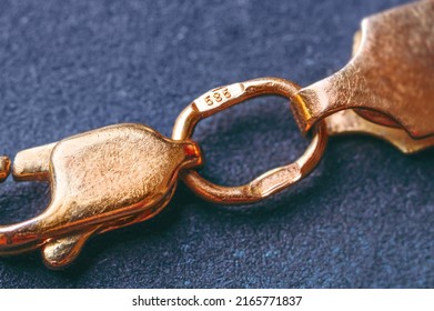 Gold 585 stamp. Gold clasp of a golden bracelet with hallmark 585. It is a type of gold, known as 14K gold. Macro photography. Cropped image. - Shutterstock ID 2165771837