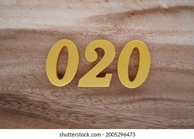 Gold Arabic numerals 020 on a dark brown to off-white wood pattern background.