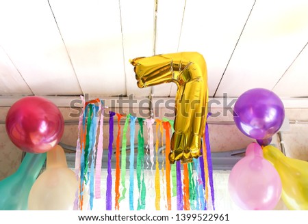 Gold balloon number 7. Child's birthdayparty decor in rural room interior