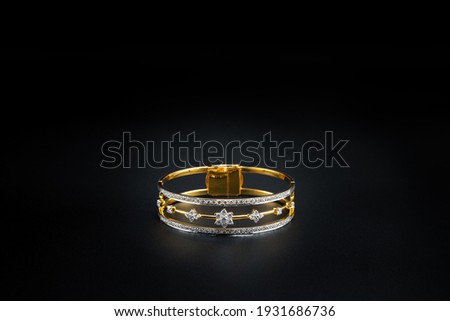 gold bangle with diamond isolated on black background, fashion and design accessory