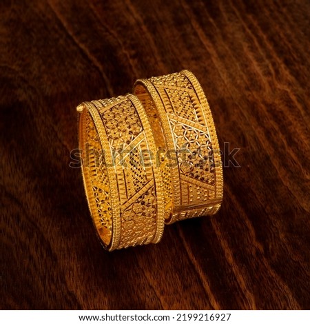 gold bangles with wooden background, beautifull jewellery
