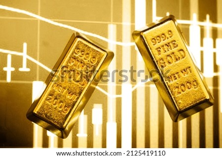 gold bar on the background of a laptop on which there is a trading price chart. Trading gold on the stock exchange and Forex.