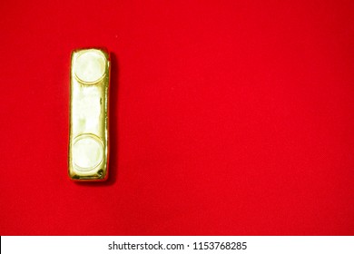 A Gold Bar On Red Background