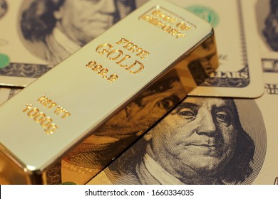 Gold bar on US dollar background. Conceptual image of gold trading, gold future, commodity trading, save heaven, currency backing and hedging