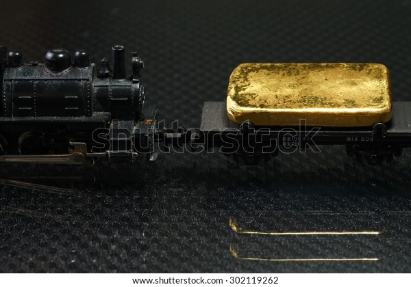 Gold bar put on the on the model\
railroad flatcar represent the business concept related\
idea.