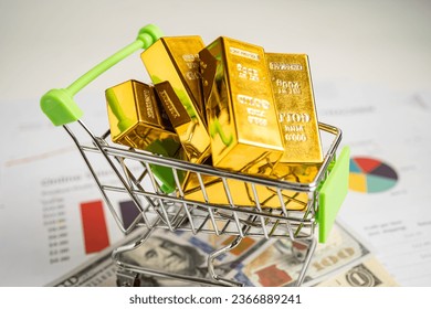 Gold bar in shopping cart on US dollar banknotes money and graph, economy finance exchange trade investment concept. - Shutterstock ID 2366889241