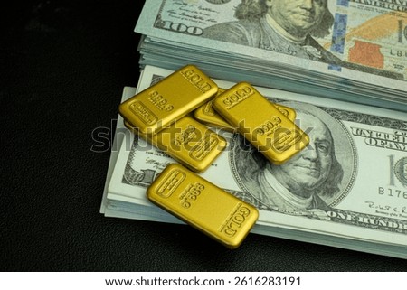 Gold bar and a stack of one hundred dollar bills on a black background representing wealth and financial success