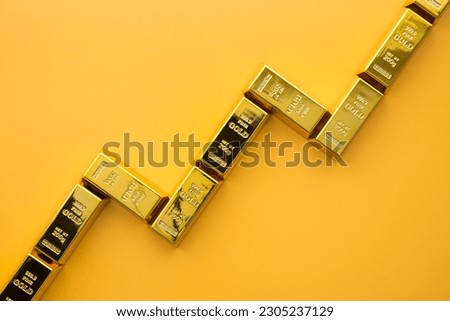 Gold bars as graph chart growing up on yellow background copy space. Gold price increase rising in commodity trading bull market investment concept. Gold is store of value in recession crisis.