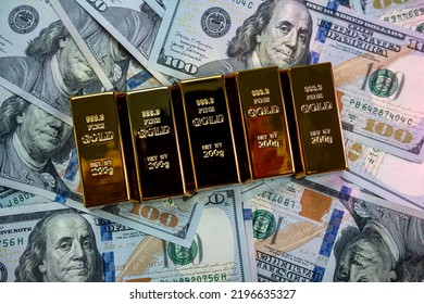 Gold Bars Lie With A Calculator Near A Large Sum Of Dollars Isolated. Concept Of Financial Savings. Gold And Dollars.