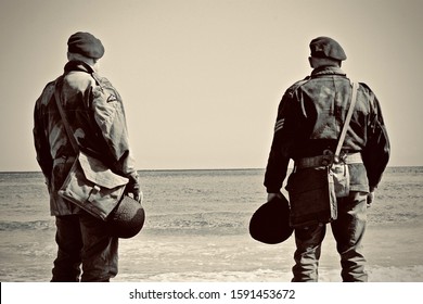 GOLD BEACH ARROMANCHES,NORMANDY,FRANCE.6th June 2019.WW2 British Soldiers Stand Looking Out Onto Gold Beach During The 75th Anniversary Of D-Day.