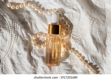 Gold Beauty Serum In A Pipette Bottle On An Ivory Fabric Regency Fashion Inspiration