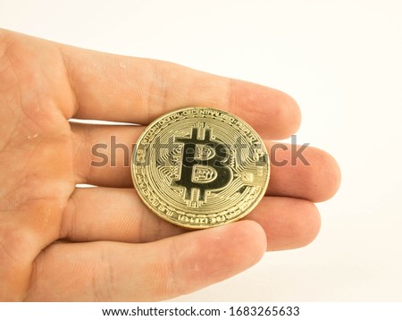 gold bitcoin coin in a man's hand on a white background