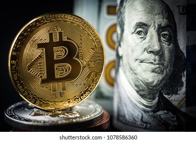 Gold bitcoin coin standing in front of dollar bills. New virtual money concept