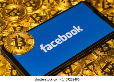 Gold Bitcoin Coins Pile With The Facebook Logo On Smartphone Screen. TOKYO, JAPAN - JULY 2, 2019