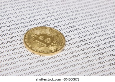 gold bitcoin on the background of binary code