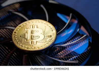 Gold bitcoins on a video card with a blue backlight in the style of cyberpunk. Cryptocurrency. Bitcoin Mining Concept