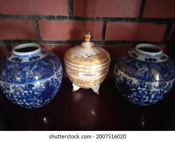 a gold bowl in between two blue chinaware