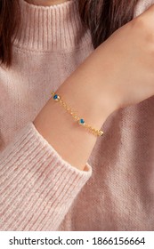 Gold Bracelet With Pink Cauldron On Ladies' Wrist.