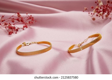 Gold bracelets jewelry on a gold background. Gifts for Valentine's Day Joyful girlfriends, women and wives pure pink and gold background.