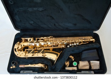 A Gold / Brass Alto Saxophone On White Background With Pearl Keys - Laid Out In Case With Accessories Including Strap, Cleaner, Reed And Cork Grease