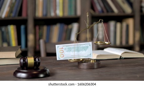 Gold Brass Scale With Money On Wooden Table Of Court Room